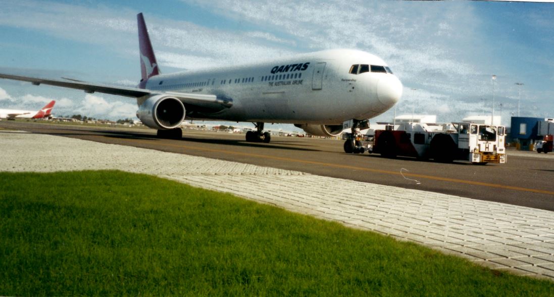 Qants airplane on tarmac at Syndey Airport with flexmat installation along the runway edge